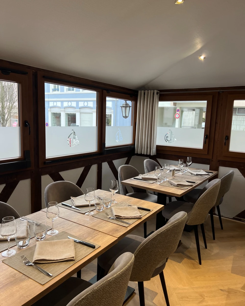La salle du restaurant, ses colombages et ses fenêtres sur la rue Principale